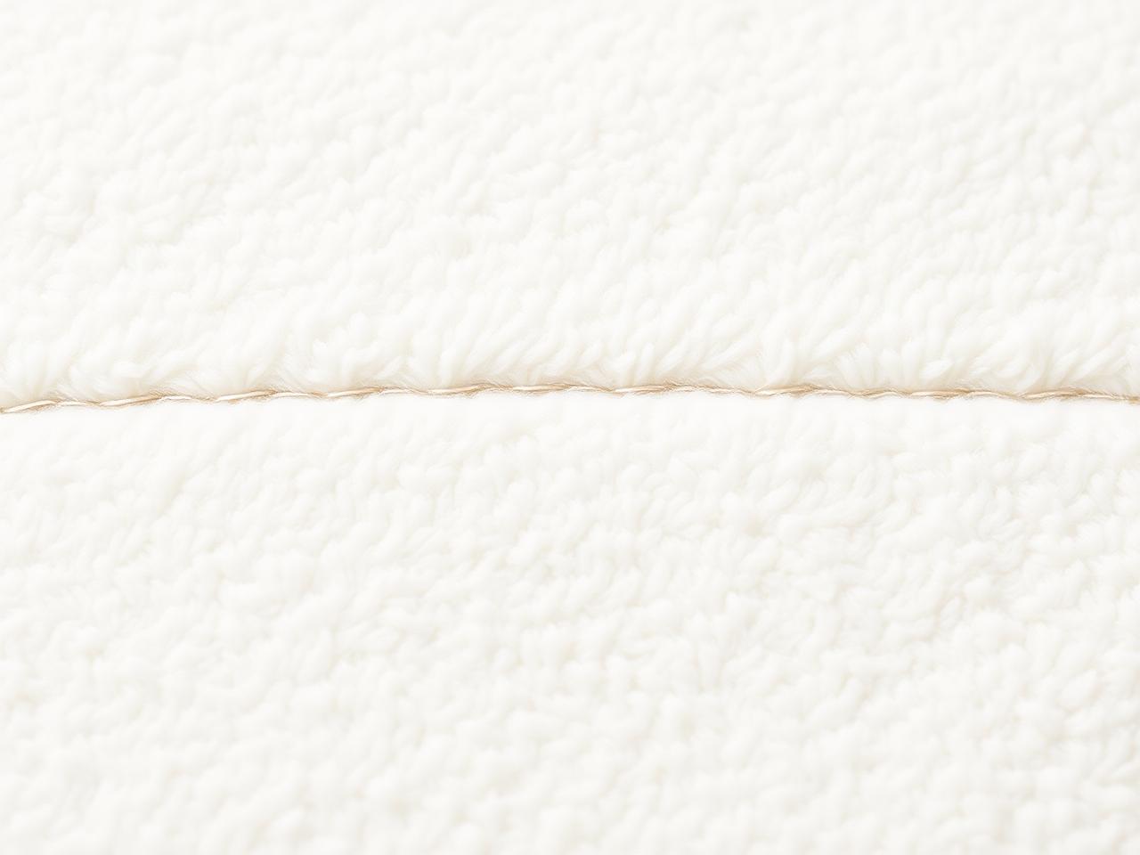 Macro detail of cream fleece fabric and stitching