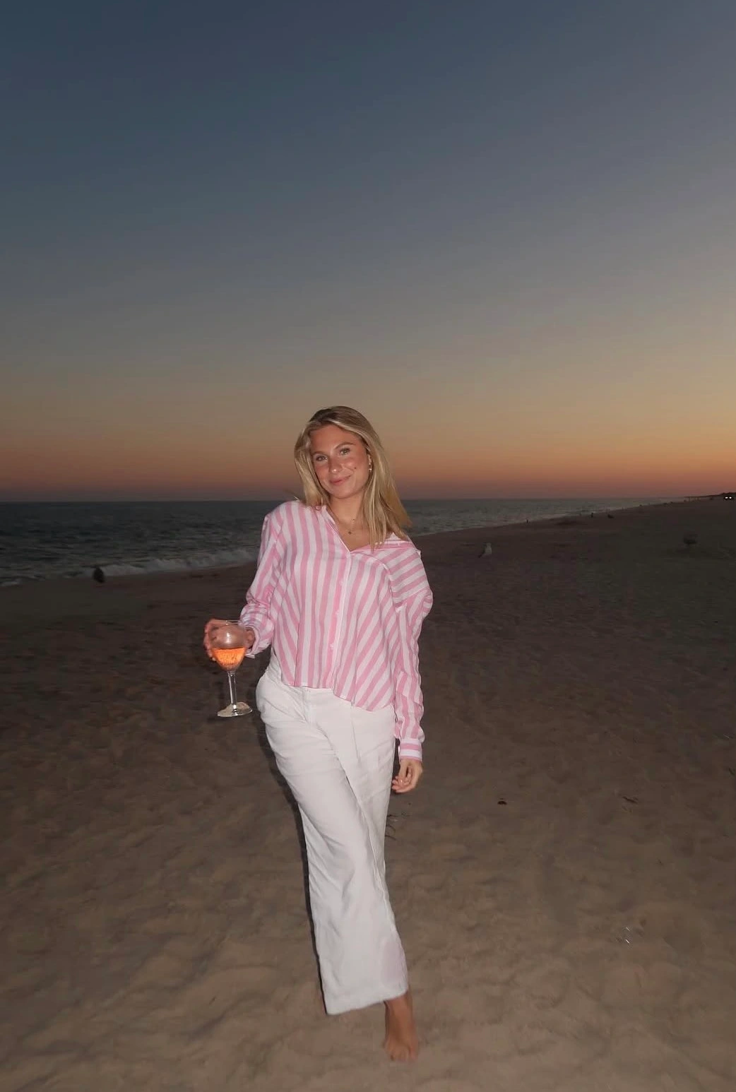 Walking a Hamptons beach at dusk in summer stripes