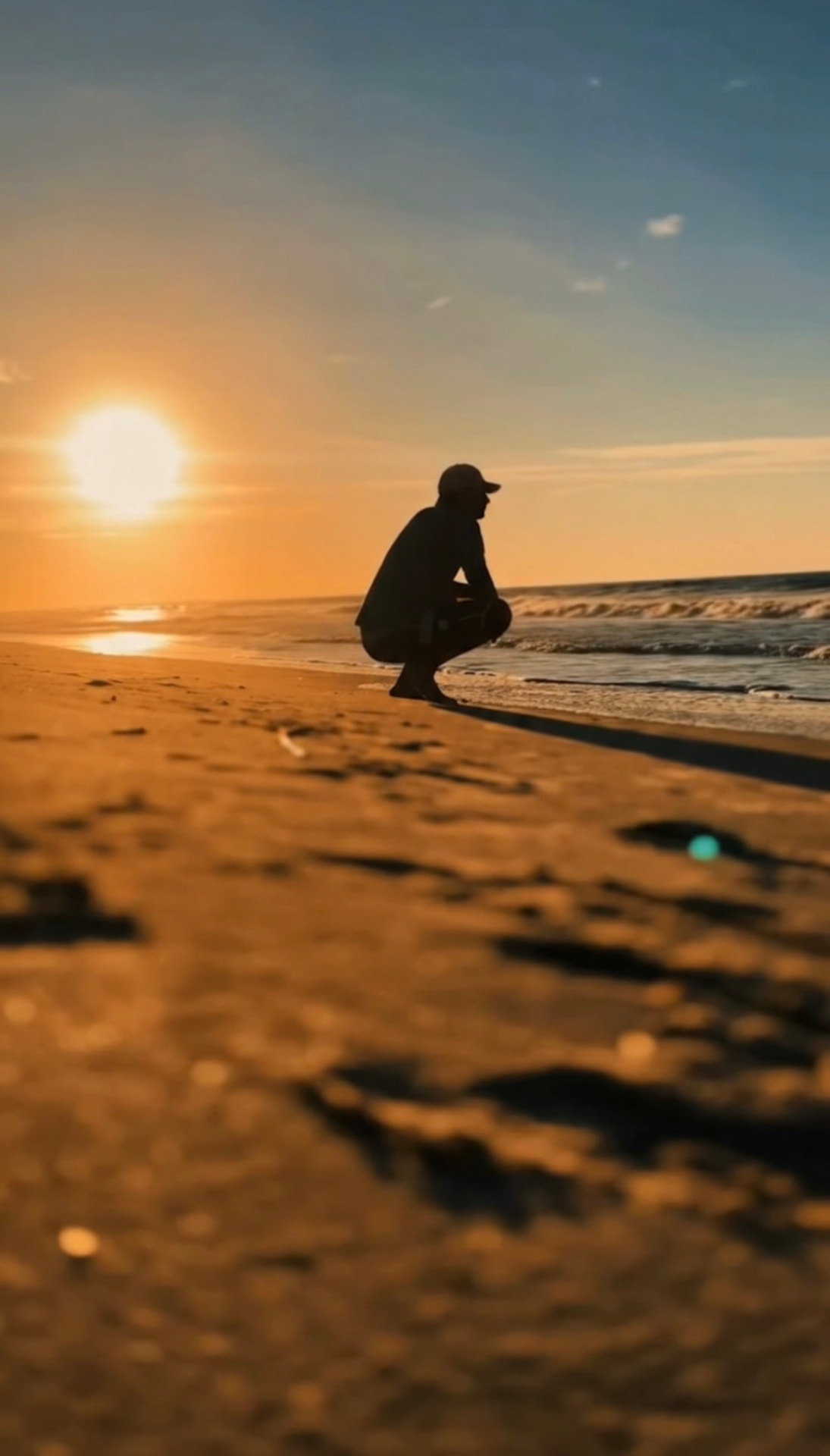 Silhouette in a cap watching sunset on a Hamptons beach