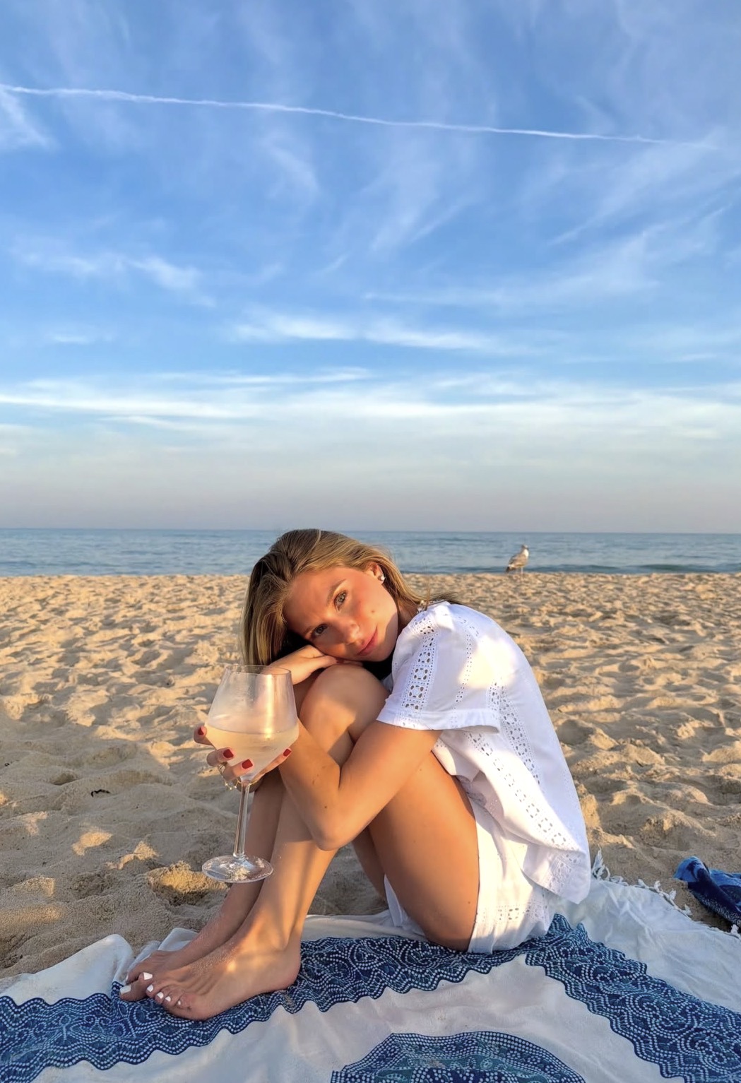 Sunset on a Hamptons ocean beach with a glass of rosé on a blanket