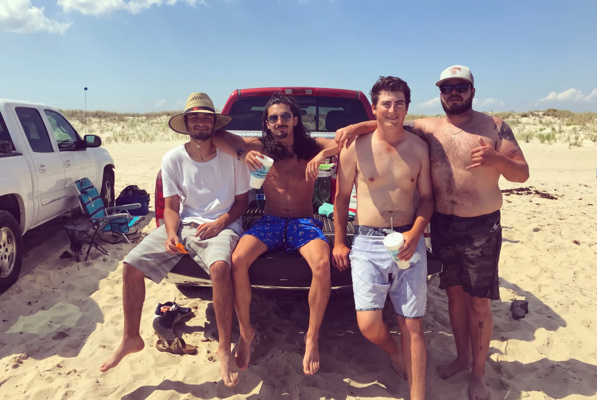 Summer tailgate with friends on a Hamptons beach in the back of a pickup truck